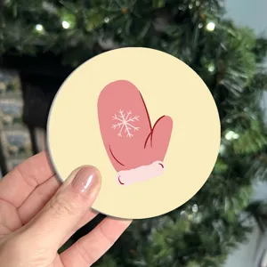 Christmas themed round coaster with cute pink winter mitten and snowflake pattern design detail.