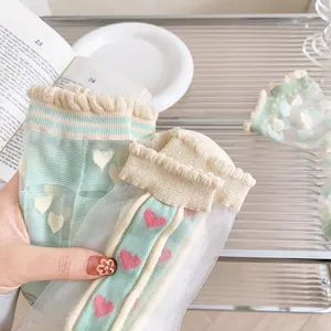 Chaussettes mi-mollet en soie transparente style japonais cœurs volants détail vue de près