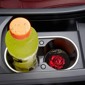 Detail van de autobekerhouder onderzetter met rood rozenpatroon in het voertuigcompartiment.
