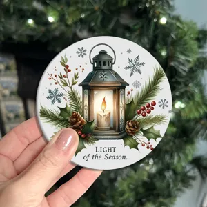 Close-up detail of a round Christmas themed coaster featuring a festive lantern and candle design.