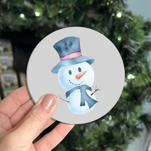 Close-up detail shot of a cute watercolor snowman round car coaster and table mat decoration.
