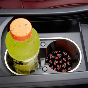 Close-up view of a cute black cherry pattern silicone car cup coaster placed in a cup holder.