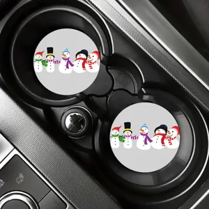 Close-up of cute cartoon snowman car coasters placed inside a vehicle cup holder for decor.