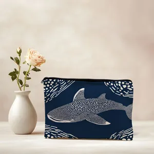 Close up detail of blue canvas cosmetic makeup bag featuring white whale shark print.