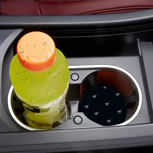 Black car cup holder coaster featuring white bow pattern, detail view inside console.