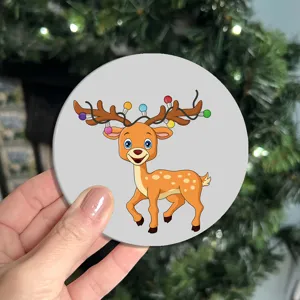 Close-up detail of the cute cartoon reindeer leather coaster with holiday lights design.