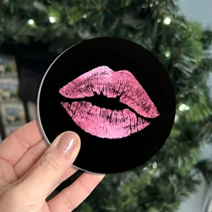 Detail van een ronde auto bekerhouder onderzetter met roze glitter lippen design.