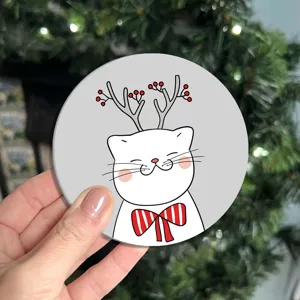 Sottobicchiere rotondo in pelle con un simpatico gatto bianco a cartone animato con corna di renna.