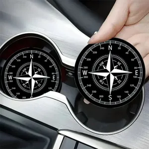 Close-up of a black and white compass pattern car cup coaster, non-slip interior accessory.