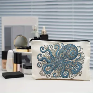 Detail shot of white canvas makeup bag featuring intricate blue octopus pattern and secure zipper.