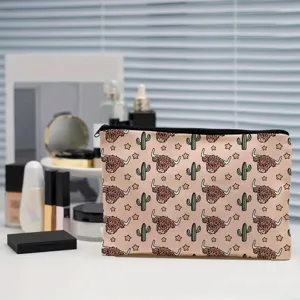 Detail shot of canvas cosmetic bag featuring cute highland cow and cactus cartoon pattern.