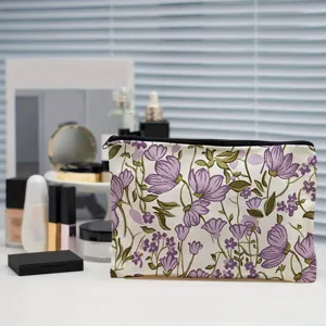 Detailed view of portable canvas makeup pouch featuring purple floral pattern for cosmetic storage.