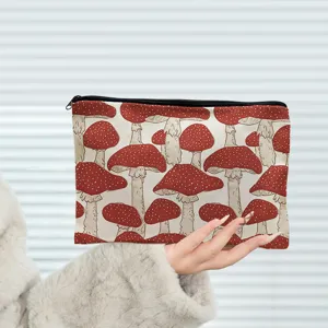 Canvas cosmetic pouch detail featuring red mushroom botanical pattern for portable storage.