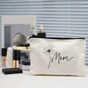 Nahaufnahme der weißen Canvas Kosmetiktasche mit schwarzem Blumen Mom Druck und Reißverschluss.