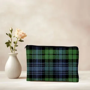 Nahaufnahme einer blau-grünen Karomuster Make-up-Tasche mit schwarzem Reißverschluss.