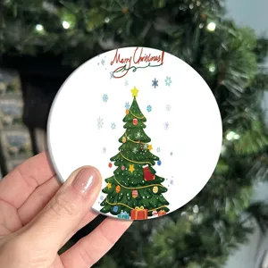 Close-up of a round Christmas diatomaceous earth coaster with tree pattern and holiday text.