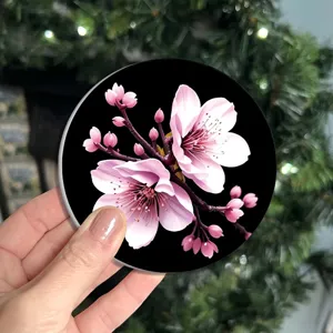 Detailed view of a round silicone cup coaster featuring a pretty pink cherry blossom floral print.