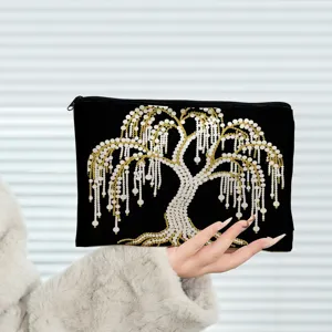 Detailaufnahme der schwarzen Kosmetiktasche mit wunderschönem goldenen Perlenweidenbaum.