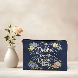 Close-up detail of a dark blue canvas cosmetic pouch with floral print and custom text.