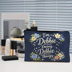 Detailed view of the dark blue custom cosmetic bag with floral and text print on white desk.