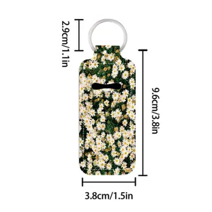 Daisy print lipstick holder keychain detail view, portable lip balm sleeve with metal ring.