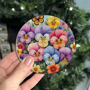 Gros plan de détail d'un set de table rond à motif de fleurs de pensées et papillon.