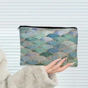 Close-up detail shot of the blue mosaic scale cosmetic pouch held by hand clearly.