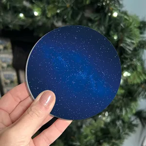 Gros plan du set de table rond avec motif de ciel étoilé sur fond de décor festif.