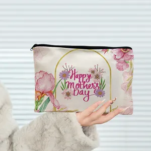 Detailed view of canvas cosmetic pouch with floral Mother's Day print and black zipper.