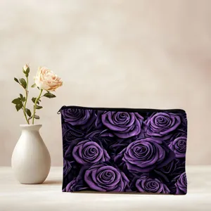 Gros plan d'une trousse de maquillage avec motif de roses violettes et fermeture éclair noire.