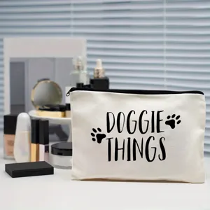 Canvas cosmetic pouch detail showing black doggie things text and cute paw prints design.