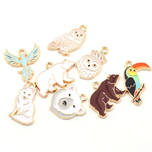 Detailed close-up of cute alloy oil-drop animal charms, owl and bear pendant designs.