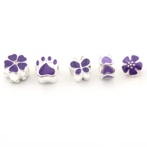 Close-up detail of silver DIY large-hole charm beads with purple enamel flowers and paws.
