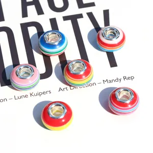 Close-up of colorful striped resin large-hole charm beads for DIY bracelet jewelry making.