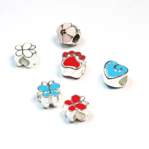 Close up detail of antique silver alloy enamel DIY charms set with colorful designs.