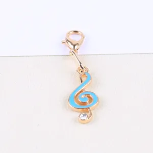 Gold-tone alloy lobster clasp charm with blue enamel treble clef pendant and crystal detail.