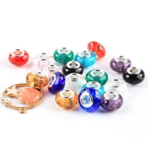 Detailed view of colorful faceted glass large hole beads and a gold shell star charm for DIY jewelry.