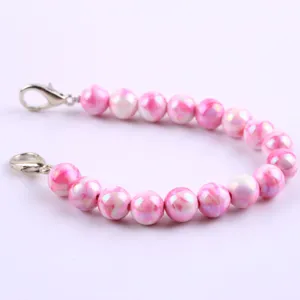 Catena di perline in resina marmorizzata rosa con moschettoni in metallo per gioielli o borsa.