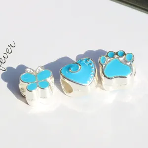 Silver alloy enamel beads close up featuring cute butterfly heart and paw print designs.