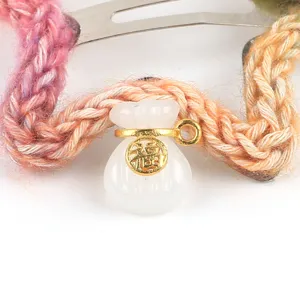 Detailopname van Chinese stijl DIY jade geldzak hanger accessoire met gevlochten koord.
