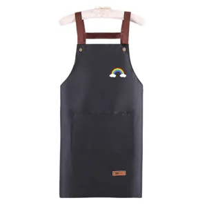 Tablier de cuisine noir imperméable avec bretelles croisées marron et poches pratiques.