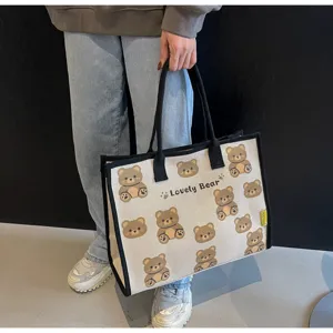 Vue détaillée du sac cabas en toile avec motif d'ours mignon, texture et impression.