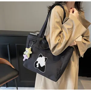 Dettaglio della borsa tote in tela di panda carina, con ricamo in spugna e ciondolo a stella.