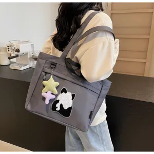 Vista dettagliata della borsa tote in tela grigia con grazioso ricamo panda e ciondolo stella.