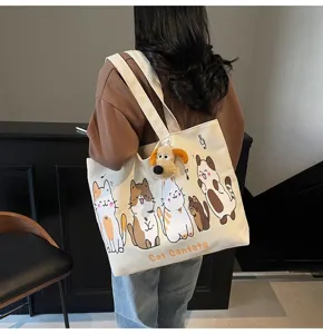 Detail shot of canvas tote bag with cute cat prints and plush dog charm, spacious.