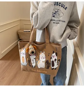 Detailed view of the cute cartoon cat brown canvas tote bag with dog plush pendant.