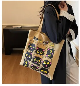 Détail de sac cabas en toile avec joli imprimé chat noir et sangle d'épaule pour les déplacements.