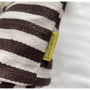 Close-up detail of the casual striped canvas tote bag showing texture and tag design.
