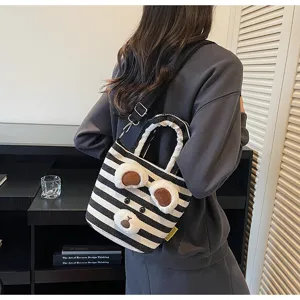 Detail shot of black and white striped tote bag with cute plush bear ears and handle.