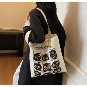 Vue détaillée du sac cabas en toile avec un joli imprimé chat noir et un design de grille.